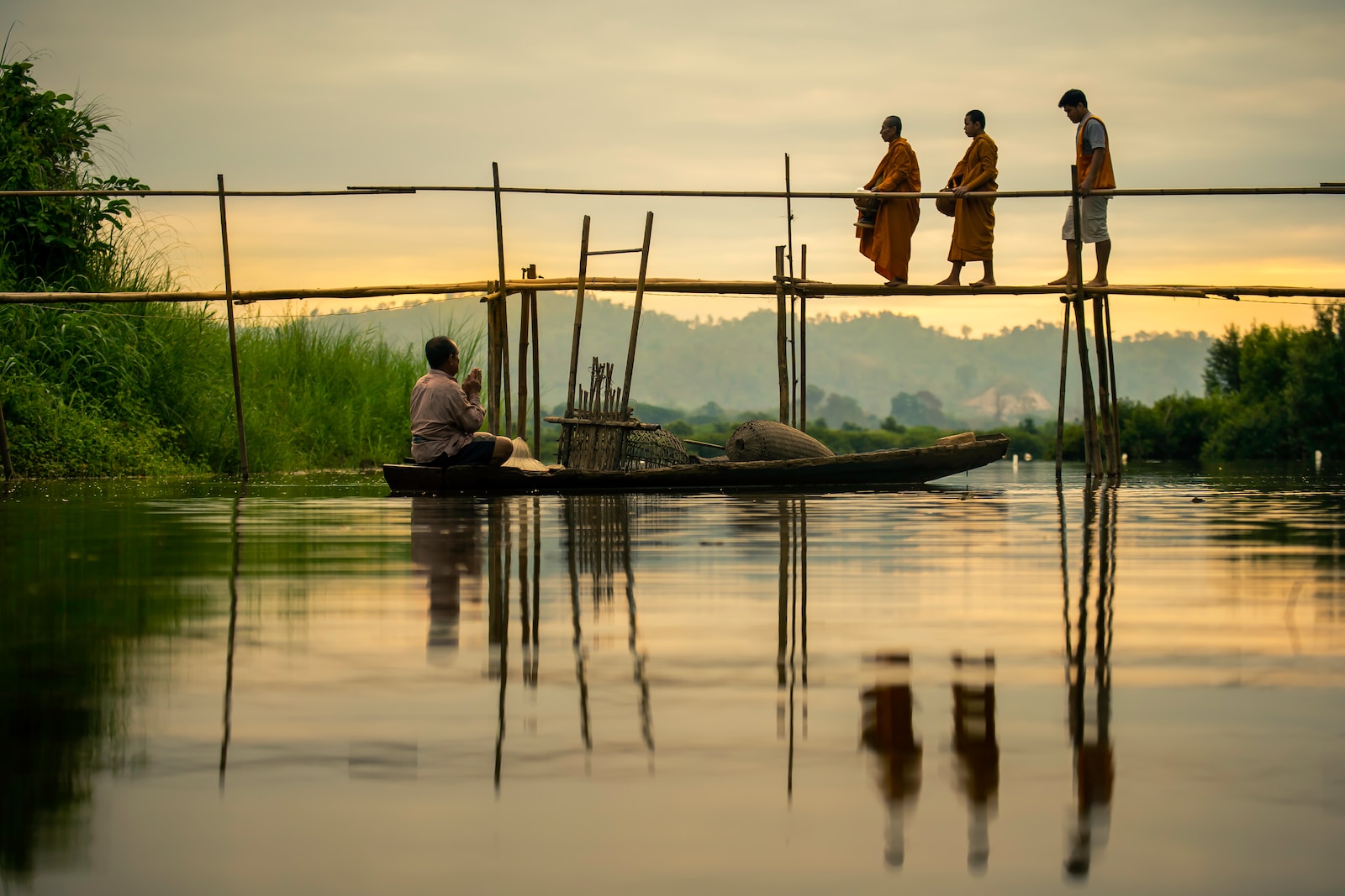 men walking across brown wooden bridge